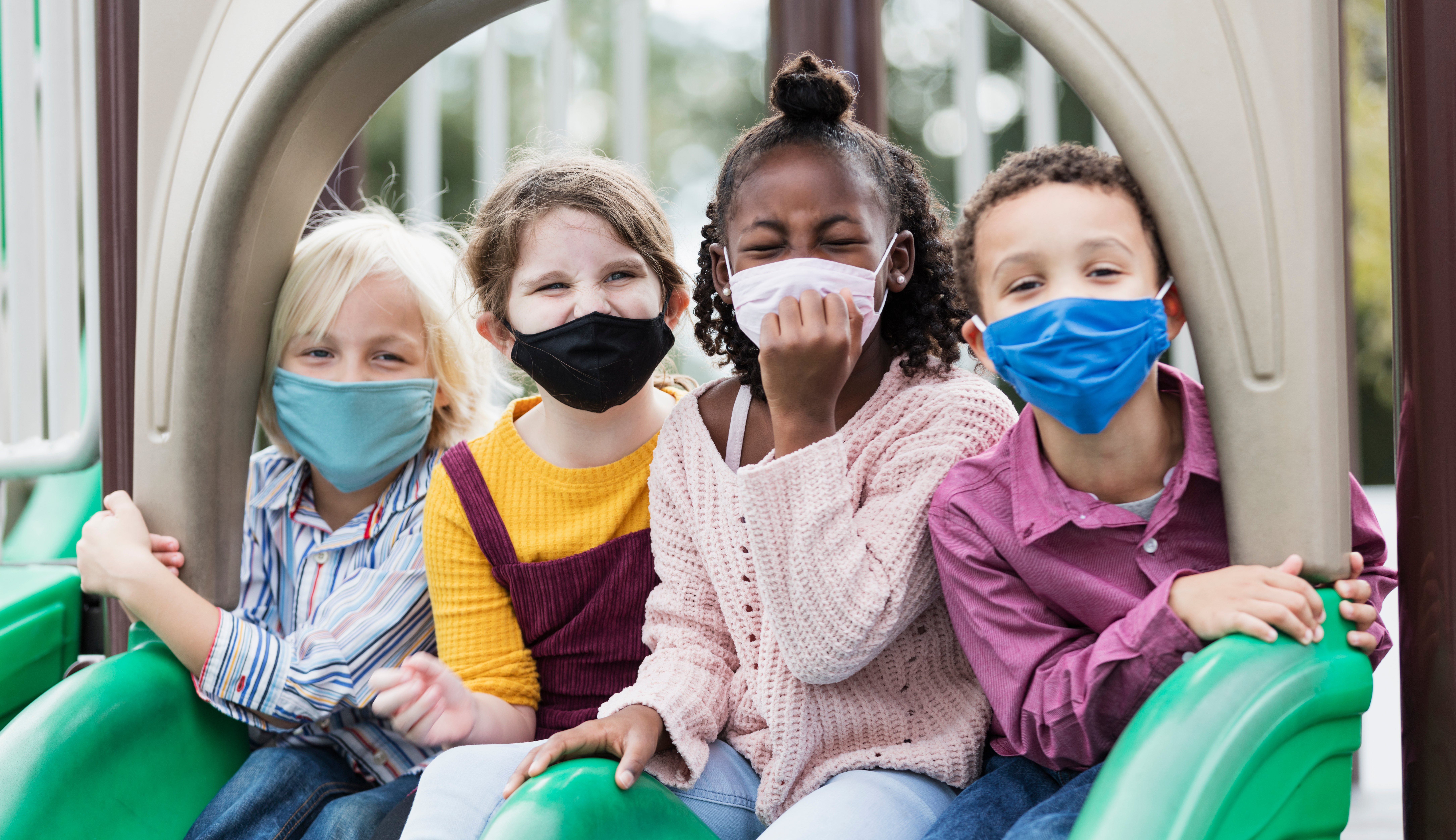 Children on playground wearing masks